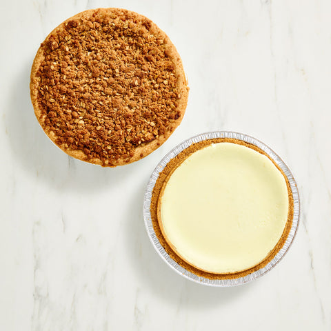 Two mini pies, one with a crumbly crust and the other with a smooth filling, on a marble surface.