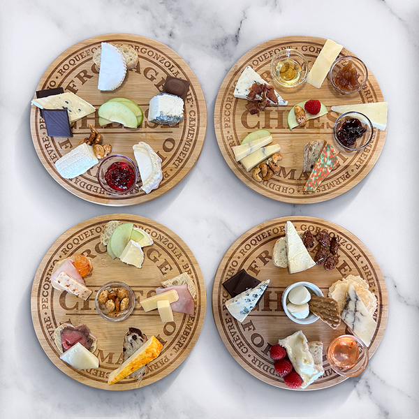 Picture of four round cheese boards from previous cheese experience classes.