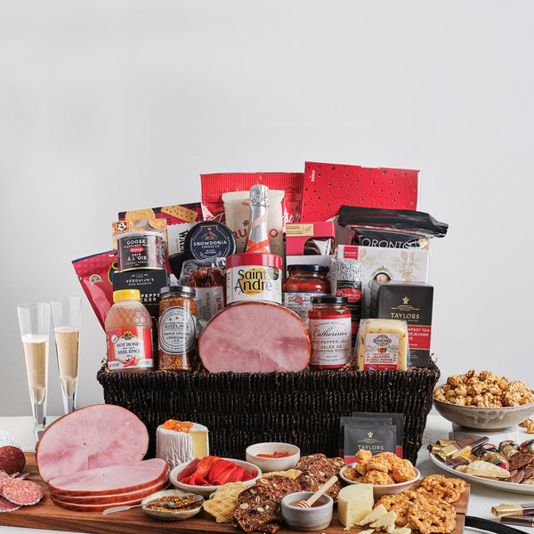 A grand gourmet gift basket with a very large selection of meat and cheese, a mini ham, pasta and sauce, snacks, chocolate and more. Includes a bottle of 13th Street Cuvée Rosé sparkling wine wrapped in large basket.