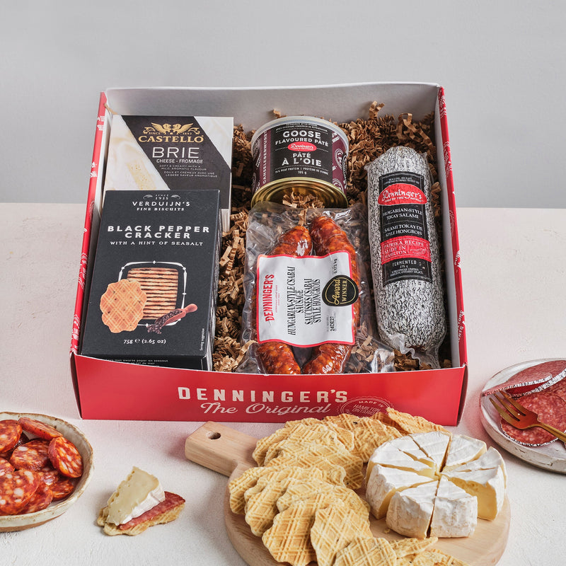 The Mini Charcuterie Box includes a Castello Brie, Denninger's German Salami, Snowdonia Chutney, Verduijns' black pepper crackers, and Denninger's Goose pate. All packed up in a lovely window box.