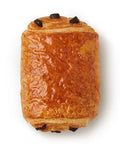 A sweet roll with three pieces of dark chocolate.
