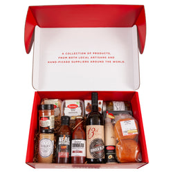 A burger kit including assorted toppings, cheese, canadian bacon, buns, and wine. Burgers not included.