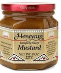 A jar of Honeycup Mustard Original with a red lid and a label showing the brand and product name, net weight 8 oz.