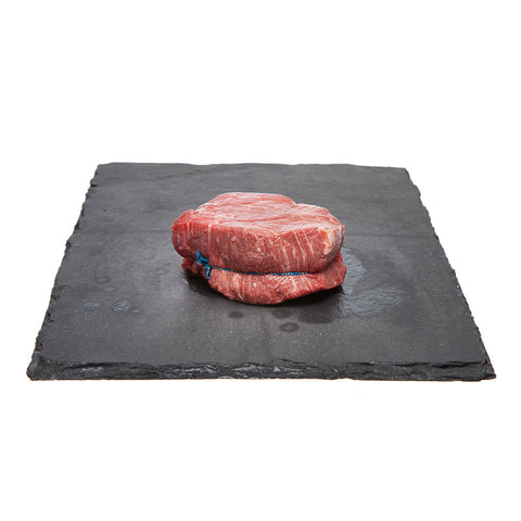 250 gram piece of raw Canadian AAA Beef Tenderloin displayed on black slate board.