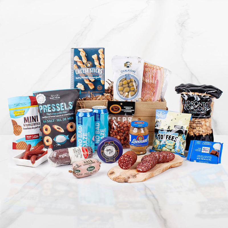 The meat and beer crate gift basket includes a variety of meats (bacon, mini salami sticks, pate, salami chub), salty snacks, popcorn, cheese, sweets and two nickelbrook brewing beers. All wrapped up in a wooden crate.