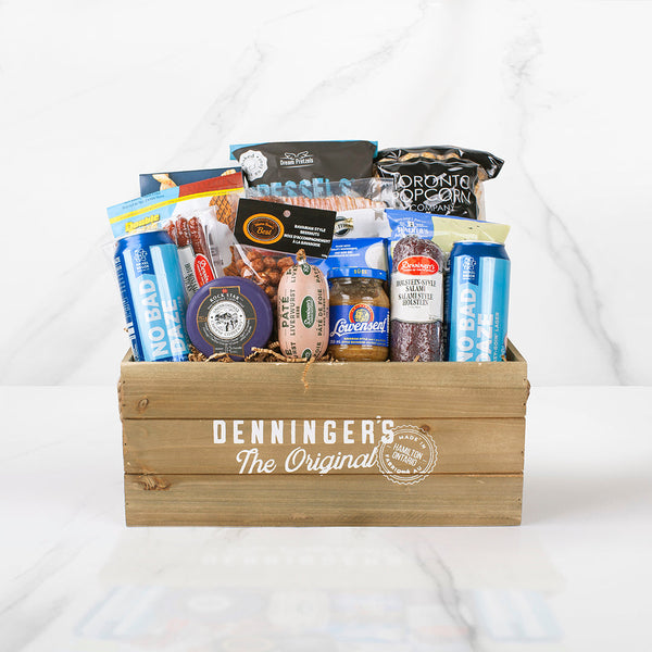 The meat and beer crate gift basket includes a variety of meats (bacon, mini salami sticks, pate, salami chub), salty snacks, popcorn, cheese, sweets and two nickelbrook brewing beers. All wrapped up in a wooden crate. 